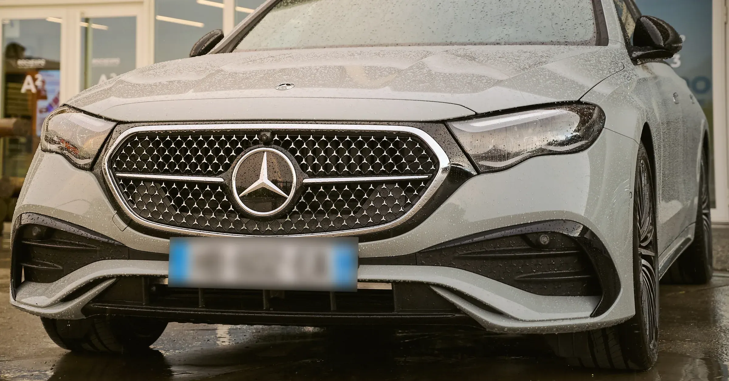 Calandre étoilée et phares LED d'une Mercedes-Benz Classe E grise perlée de pluie, photographe automobile à La Roche-sur-Foron