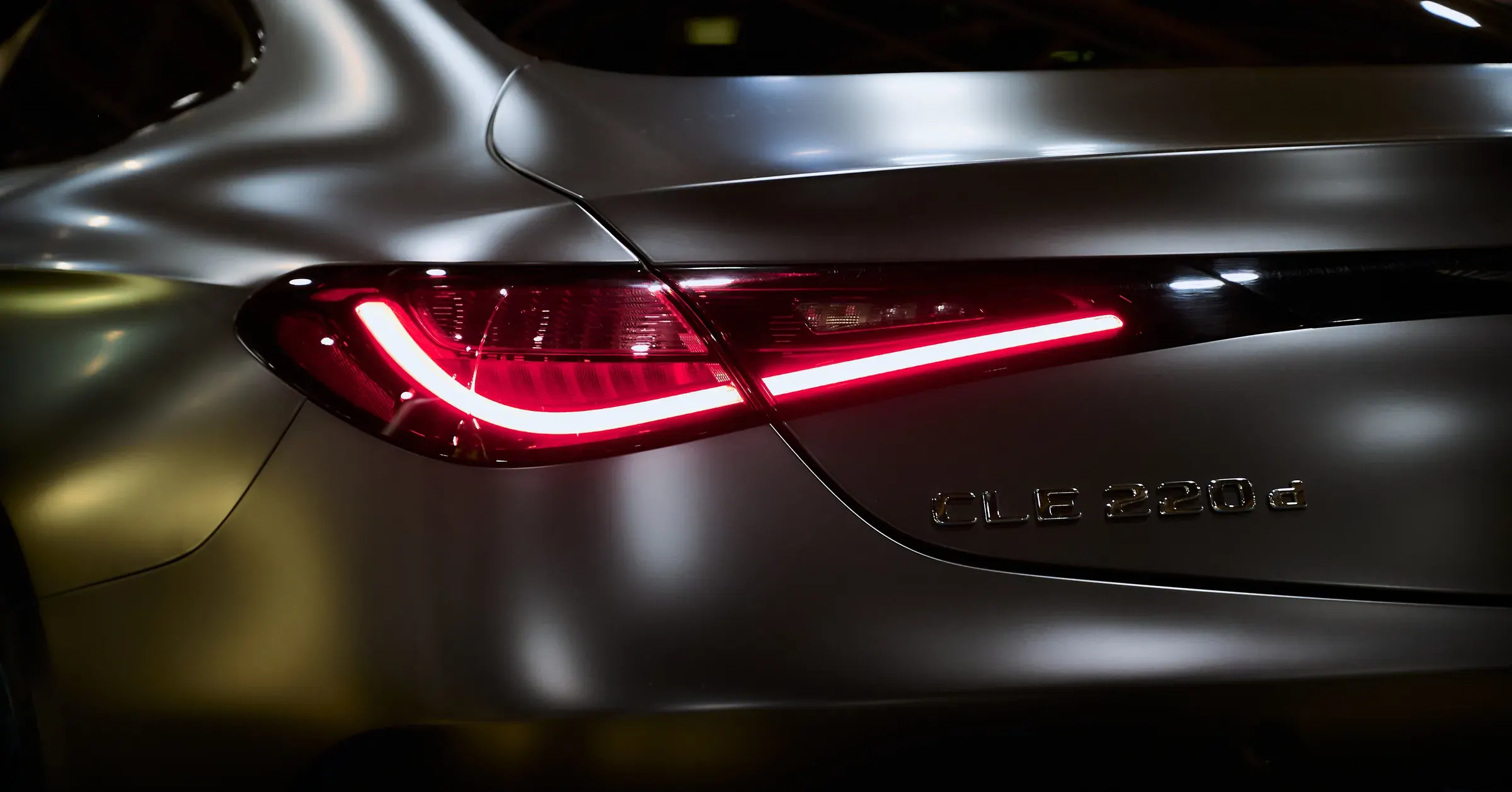 Feu arrière LED rouge et monogramme CLE 220d d’une Mercedes-Benz gris mat, photographe automobile à La Roche-sur-Foron