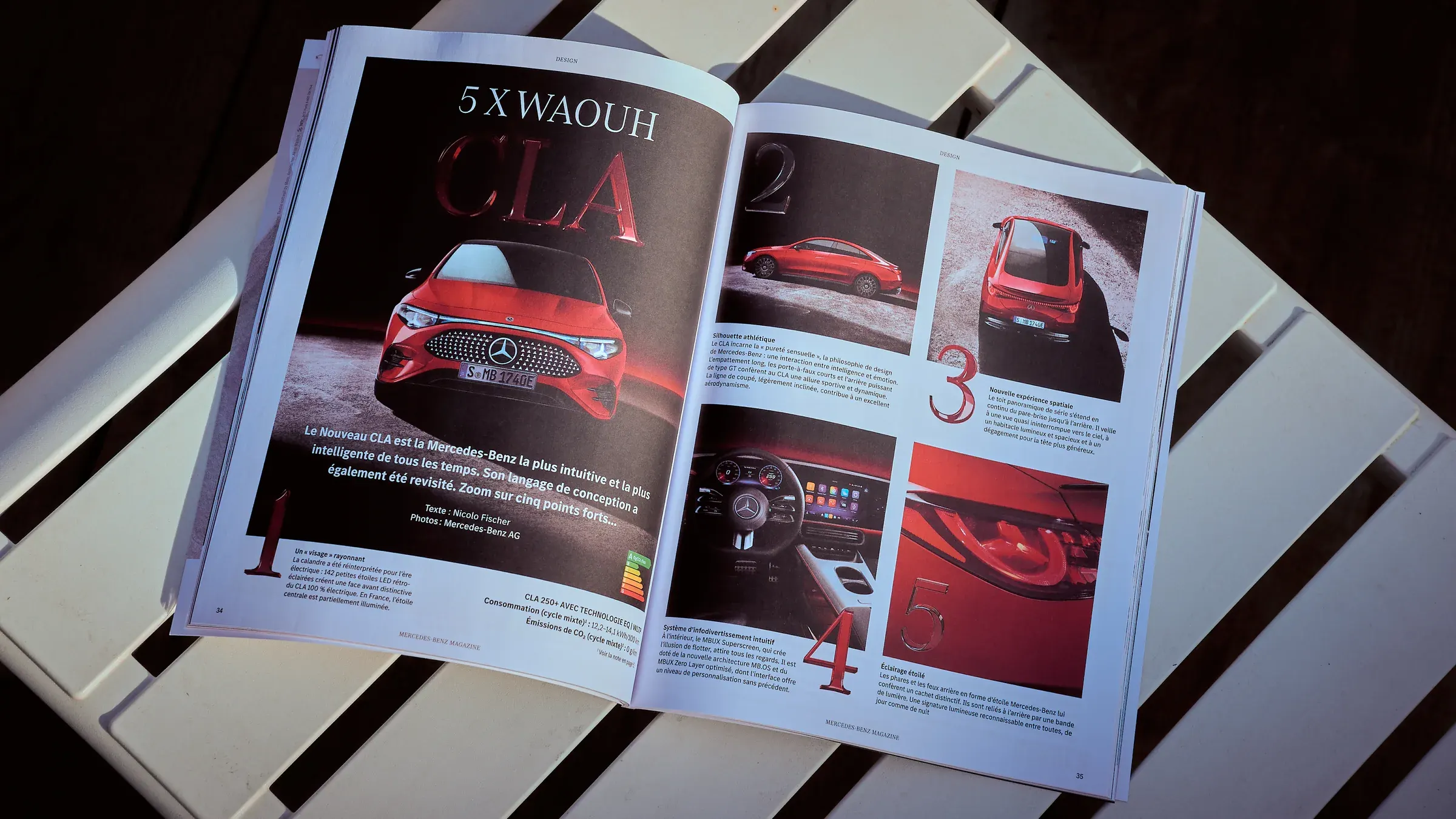 Mercedes-Benz Magazine ouvert sur le dossier CLA rouge, sur une table à lattes blanches, reportage automobile à Giez