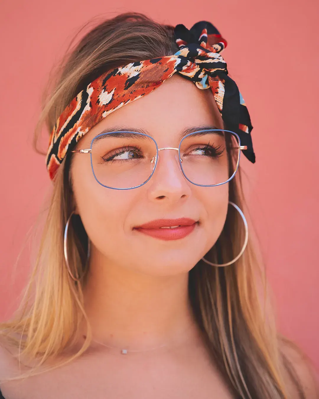 Portrait beauté d’une femme blonde à lunettes et foulard imprimé sur mur rose, lumière naturelle, Nice Côte d’Azur