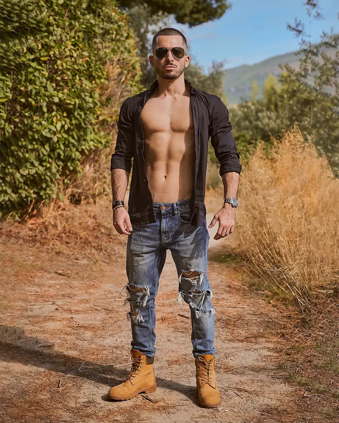 Portrait fitness masculin en extérieur, chemise ouverte et torse sculpté, sur un sentier de garrigue méditerranéenne, Côte d’Azur