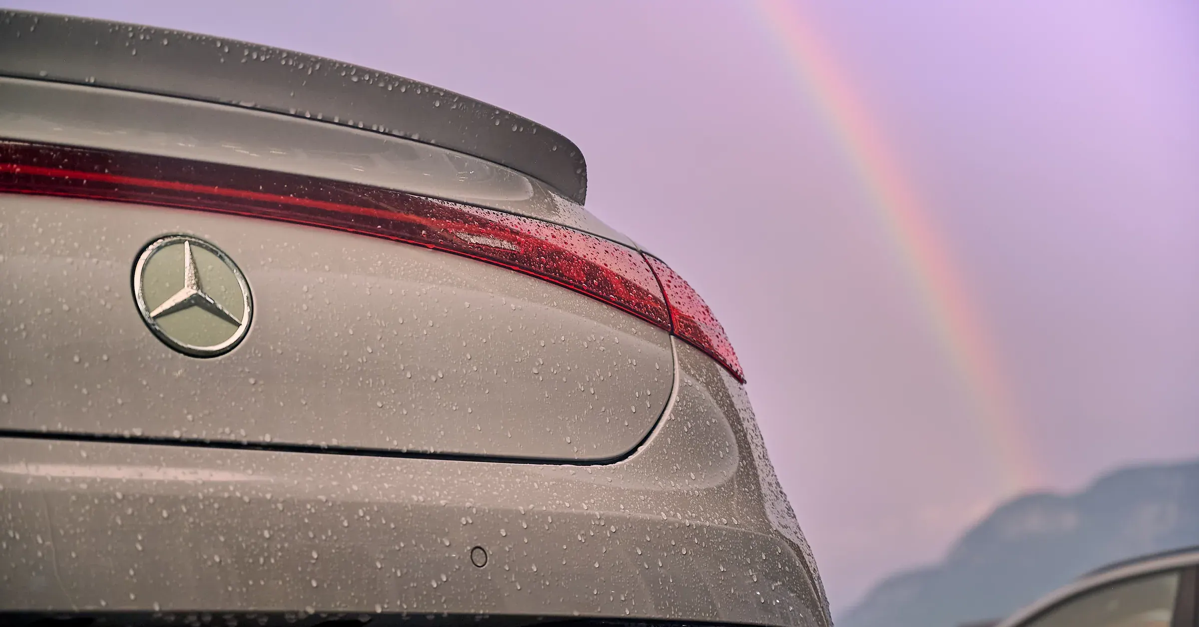 Poupe d'une Mercedes-Benz grise perlée de pluie, feux LED rouges et arc-en-ciel à La Roche-sur-Foron, photographe automobile