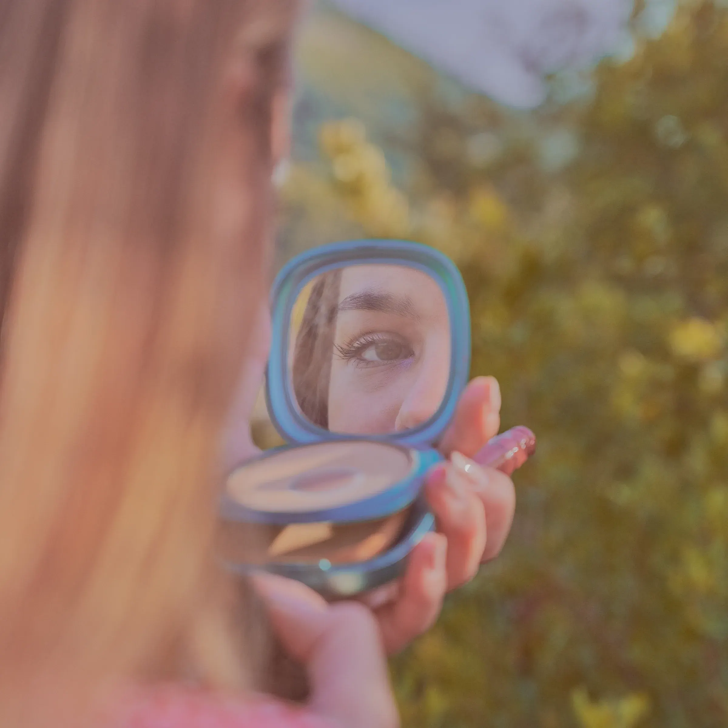 Regard féminin reflété dans un miroir de poche bleu, lumière dorée en plein air, portrait par un photographe à Nice