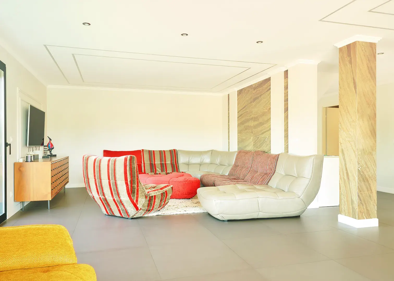 Salon contemporain d’une villa de luxe, canapés design et colonnes en marbre, photographie immobilière en Suisse romande