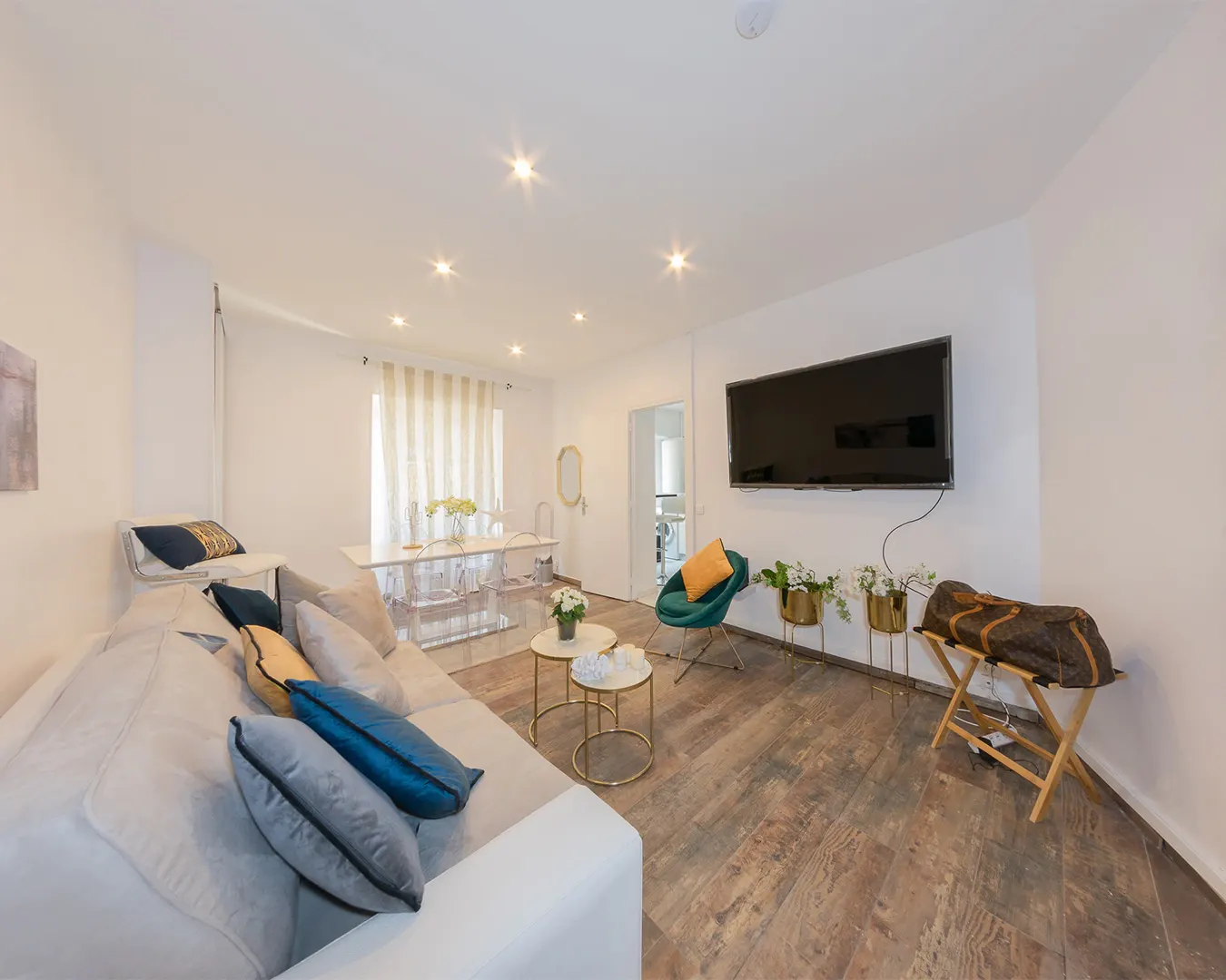 Salon lumineux d’un appartement contemporain, canapé et écran mural, photographie immobilière en Suisse romande et France