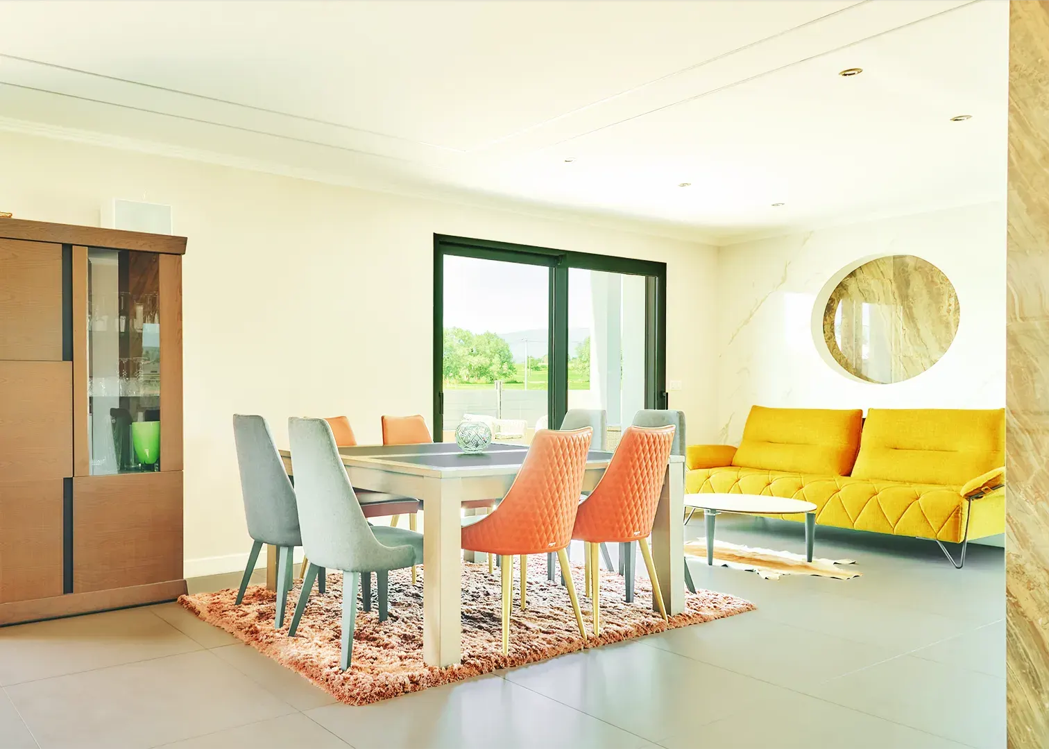 Séjour lumineux avec salle à manger et canapé jaune, photographie immobilière en Suisse romande