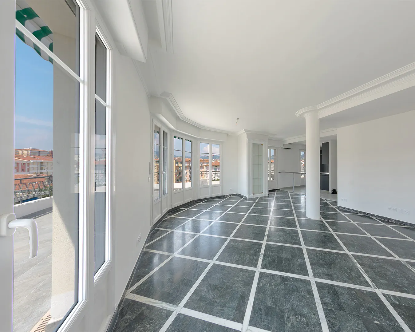 Vaste séjour lumineux d’un appartement de standing, sol en marbre et baies vitrées, photographie immobilière Côte d’Azur