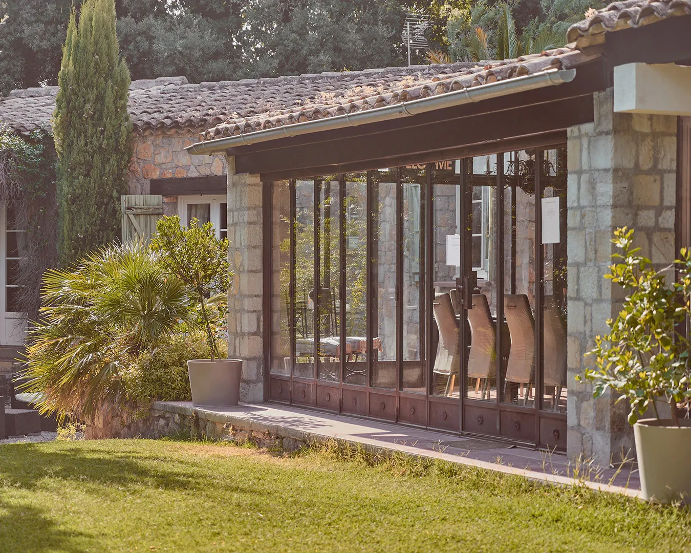 Véranda en verrière d’une villa provençale en pierre avec jardin, photographie immobilier sur la Côte d’Azur